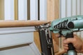 ÃÂºCarpenter brad using nail gun to Moulding trim, with the warning label that all power tools Royalty Free Stock Photo