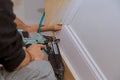 Carpenter brad using nail gun to Moulding trim, with the warning label that all power tools Royalty Free Stock Photo