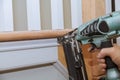 Carpenter brad using nail gun to Moulding trim, with the warning label that all power tools Royalty Free Stock Photo