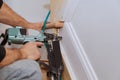 Carpenter brad using nail gun to Moulding trim, with the warning label that all power tools Royalty Free Stock Photo