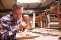 Carpenter Carving Wood Using Chisel