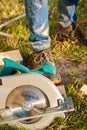 Carpenter with a circular saw in sawdust. Carpentry work Builder saws a board with a circular saw Royalty Free Stock Photo