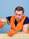 Carpenter concept. Carpenter, woodworker, builder on concentrated face hammering nail into wooden board. Man, handyman Royalty Free Stock Photo