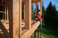 Carpenter constructing wooden frame house.