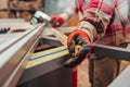 Worker in a carpentry shop measures plywood for cutting Royalty Free Stock Photo