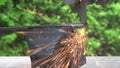 A carpenter cuts a steel rod with an electric hammer on workbench. Macro. A narrow zone of sharpness.