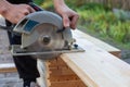 a carpenter cuts wooden floorboards