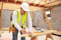 Carpenter Cutting House Roof Supports On Building Site