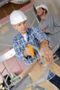 Carpenter cutting house roof supports on building site Royalty Free Stock Photo