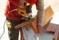 Carpenter cutting with a jig saw the beech wood stair step of a staircase