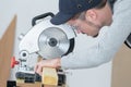 Carpenter cutting plank wood with circular disc saw Royalty Free Stock Photo