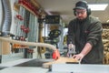 carpenter cutting wood by using a table saw in his studio handicraft concept Royalty Free Stock Photo