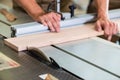 Carpenter cutting wooden board with circular saw