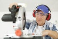 Carpenter cutting wooden plank with circular saw wearing safety Royalty Free Stock Photo