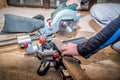 Carpenter cutting wooden plank using professional sliding compound mitre saw Royalty Free Stock Photo