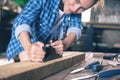 A carpenter deals with wood in a home workshop, planed planing machine planks of wood