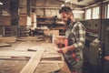 Carpenter doing his work in carpentry workshop. Royalty Free Stock Photo