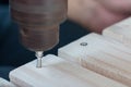 Carpenter drill a wooden board with an electric dril