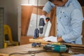 Carpenter drilling a hole in timber, Carpenter working on woodworking machines in carpentry shop, male carpenter drilling a hole Royalty Free Stock Photo