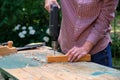 Carpenter drilling wooden plank using electric drill machine, closeup view. Craftswoman working outdoors. DIY, woodworking concept Royalty Free Stock Photo