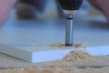 Carpenter drills round hole for door hinges in chipboard making furniture. Royalty Free Stock Photo