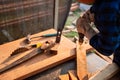 Carpenter drills wood a hole with an electrical drill