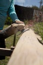 Carpenter with an electric sander working. Wood log in the sanding process