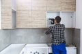 The carpenter finalizing the assembly of the kitchen shelf Royalty Free Stock Photo