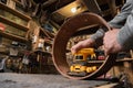 Carpenter grinding wooden drum shell from inside with sandpaper