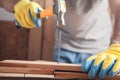 Carpenter with hammer hitting nail on wooden plank Royalty Free Stock Photo