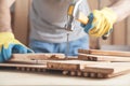 Carpenter with hammer hitting nail on wooden plank Royalty Free Stock Photo