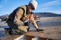 Carpenter hammering nail into OSB panel while building wooden frame house. Royalty Free Stock Photo