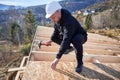 Carpenter hammering nail into OSB panel while building wooden frame house. Royalty Free Stock Photo