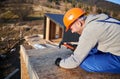 Carpenter hammering nail into OSB panel while building wooden frame house. Royalty Free Stock Photo