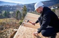 Carpenter hammering nail into OSB panel while building wooden frame house. Royalty Free Stock Photo