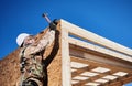 Carpenter hammering nail into OSB panel while building wooden frame house. Royalty Free Stock Photo