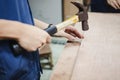 Carpenter hammering nail into piece of wood