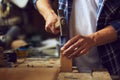 Carpenter hammering a nail into wooden plank