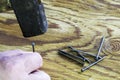 a carpenter hammers a nail into a wooden surface with a hammer