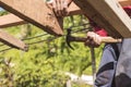 A carpenter hammers and wedges in a wood rafter. Building or reconstructing a wooden roof frame for a rural home