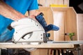 Carpenter with hand circular saw at work. closeup of sawing cut of pine wood woodworking construction tool concept furniture