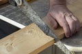 Carpenter hand with old handsaw cutting wooden boards