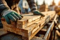 Carpenter Handling Wooden Planks on Construction Site at Sunset Royalty Free Stock Photo