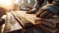 Carpenter Handling Wooden Planks on Construction Site at Sunset Royalty Free Stock Photo