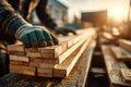 Carpenter Handling Wooden Planks on Construction Site at Sunset Royalty Free Stock Photo