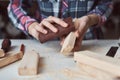 Carpenter hands polishing wooden planks with a sandpaper. Concept of DIY woodwork and furniture making