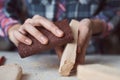 Carpenter hands polishing wooden planks with a sandpaper. Concept of DIY woodwork and furniture making Royalty Free Stock Photo