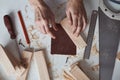 Carpenter hands polishing wooden planks with a sandpaper. Concept of DIY woodwork and furniture making