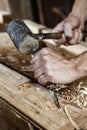 Carpenter hands working with a chisel and hammer Royalty Free Stock Photo