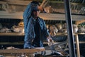 A carpenter with a handsaw sawing a wooden Board in the workshop Royalty Free Stock Photo